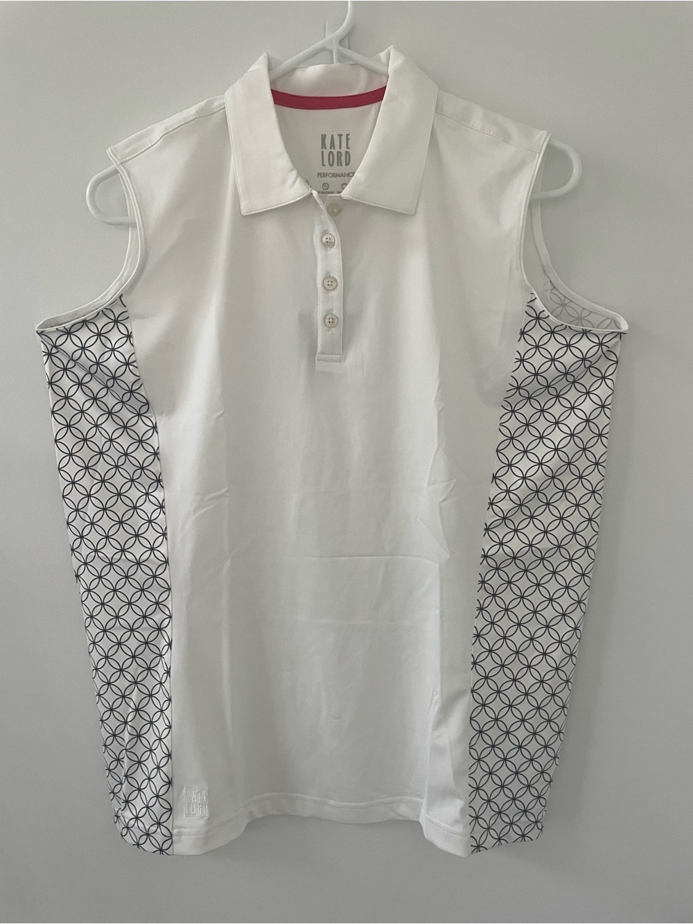 Kate Lord Sleeveless Golf Shirt in White with Black Geometric design.